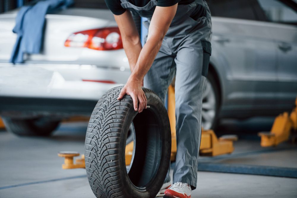 Mechanic Rolling a Tyre in Garage 