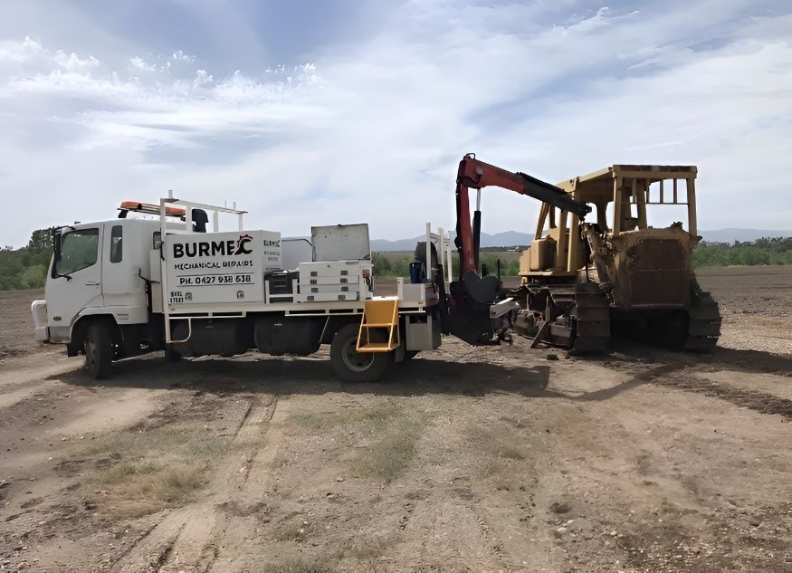 A Bulldozer is Being Towed by a Truck in a Dirt Field — Burmec In Narrabri, NSW