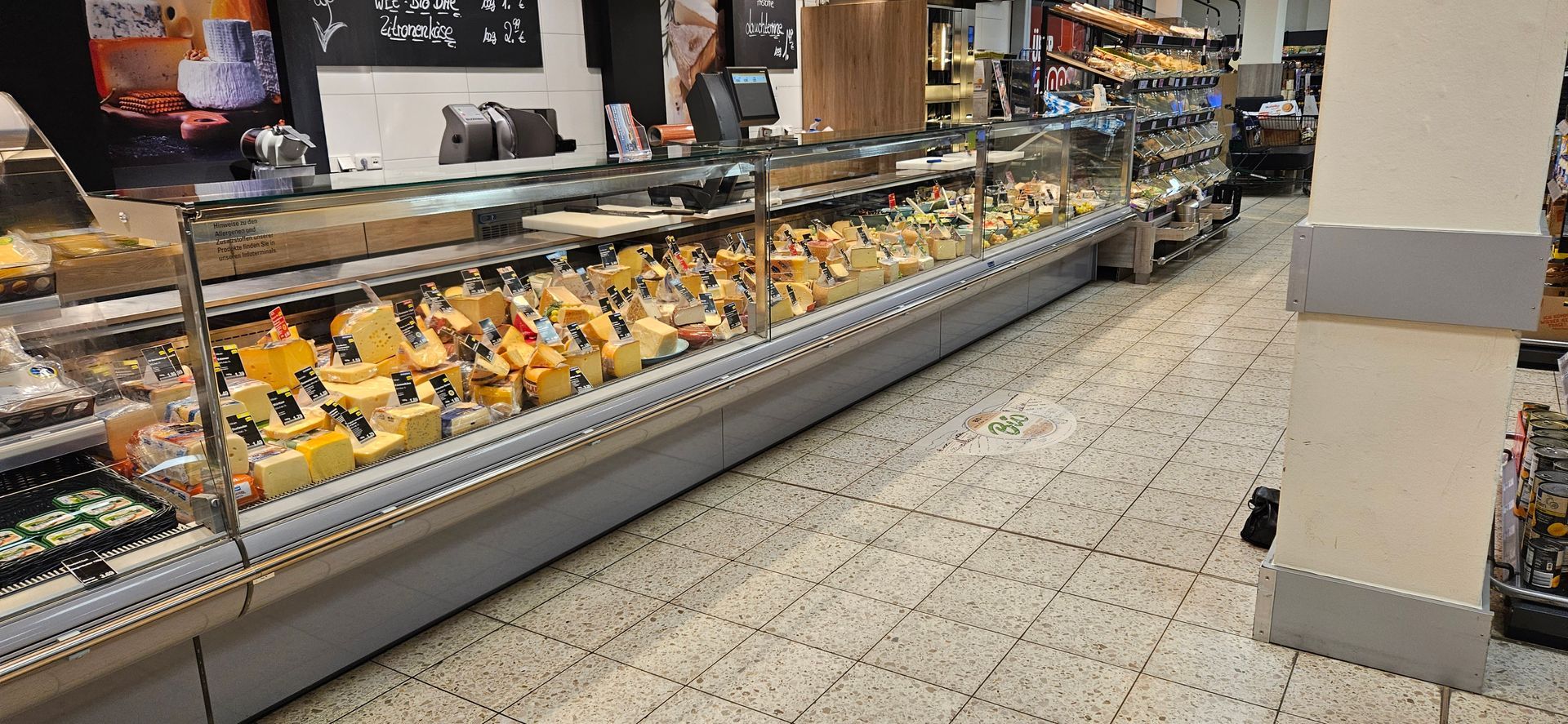 Offene Käsetheke in einem Fachgeschäft mit gekühlter Warenpräsentation