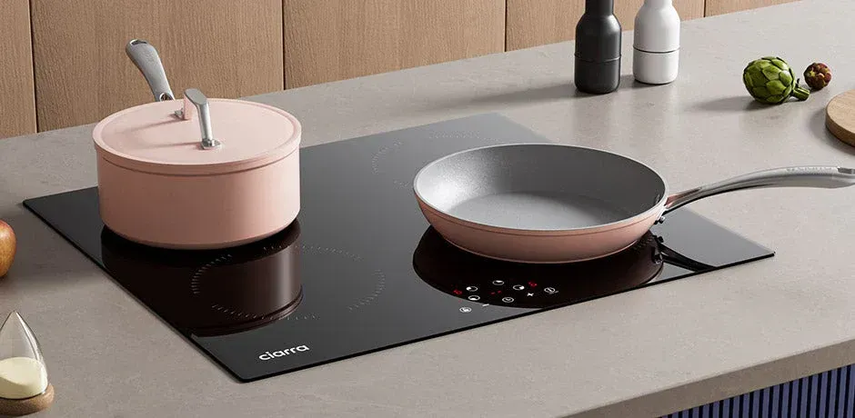 Pink pots and pans on an induction stove