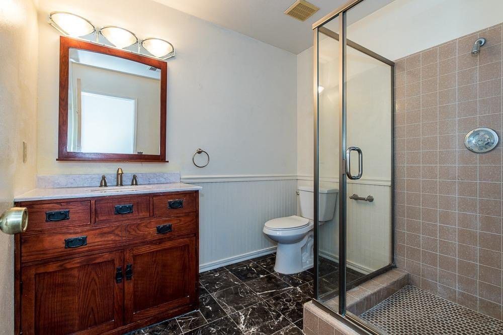 A white bathtub with beige tile walls and floor. A soap dish is mounted on the wall.