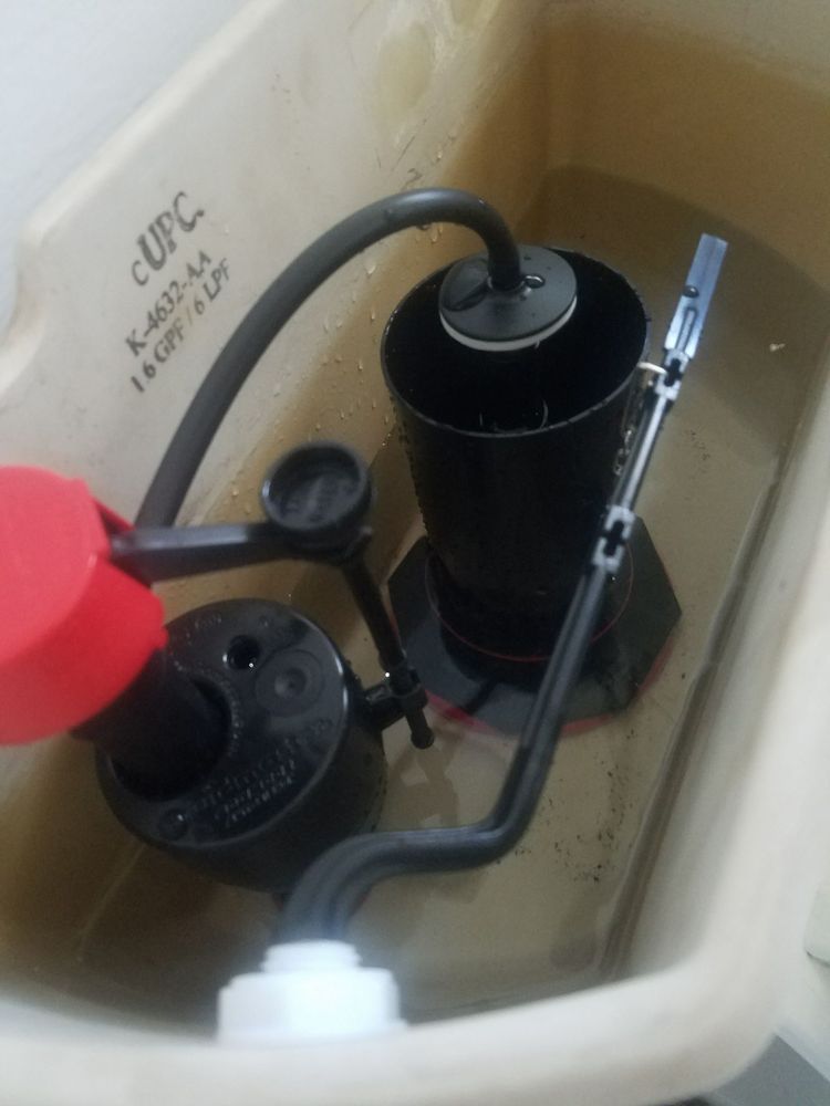 Toilet tank with float valve, fill tube, and overflow tube inside beige cistern