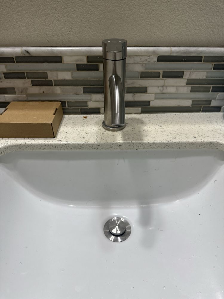 A white bathtub with beige tile walls and floor. A soap dish is mounted on the wall.
