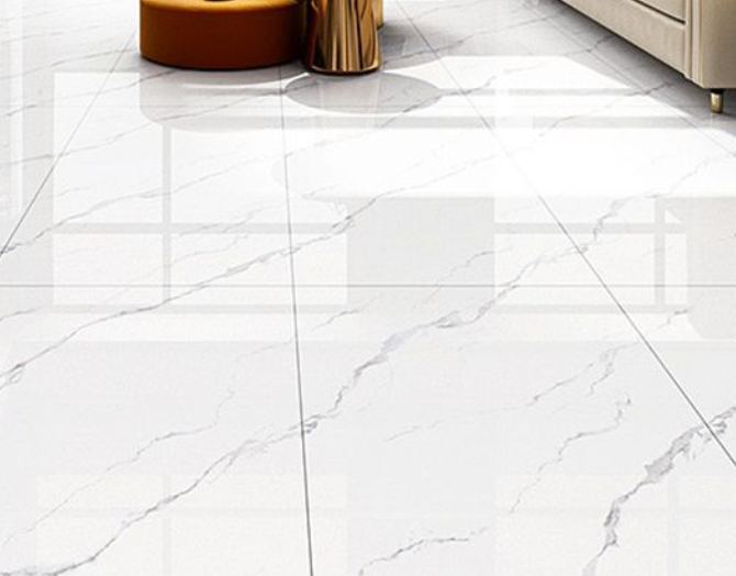 White marble tile floor with gray veining, beside a beige sofa and a small brown side table.