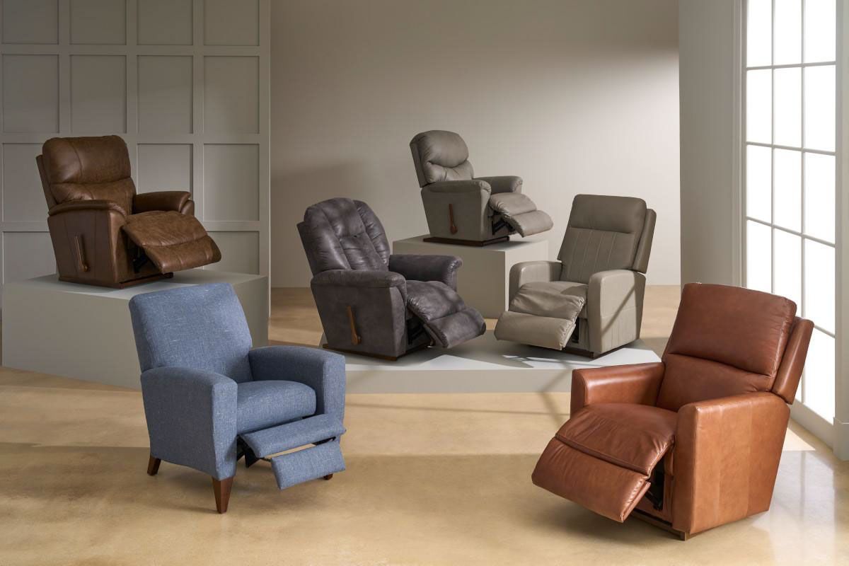 Assorted recliner chairs in blue, brown, gray, and beige arranged in a bright showroom room