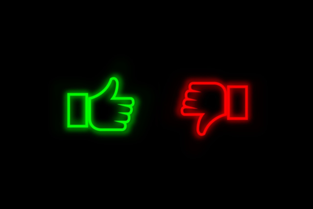 A green neon thumbs up and a red neon thumbs down on a black background.