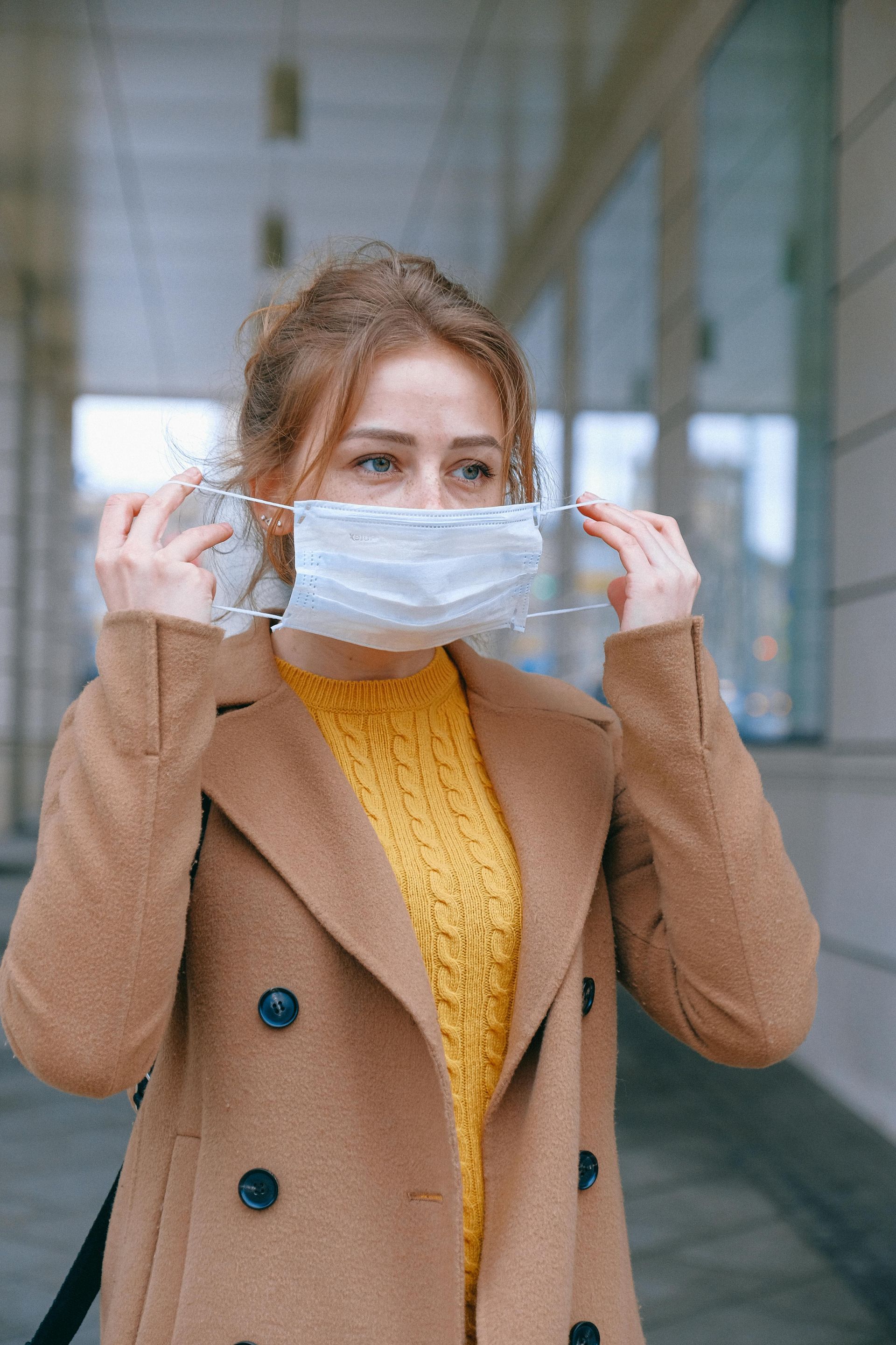 A woman is wearing a medical mask on her face.