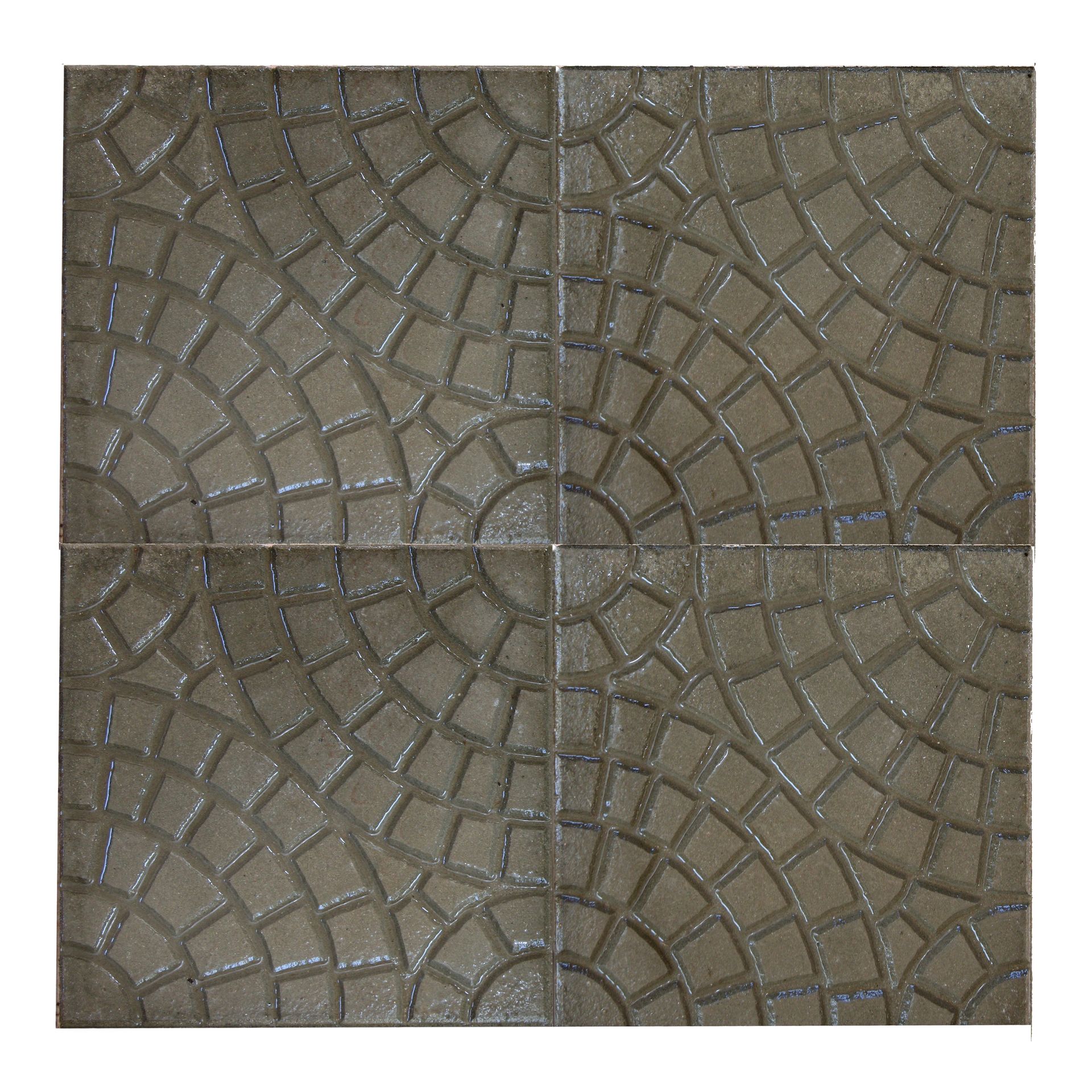 Quattro piastrelle grigie disposte a formare un motivo circolare decorativo, adatto per pavimenti o pavimentazioni.