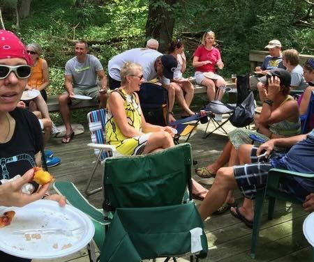 Group of people seated outdoors eating and socializing.