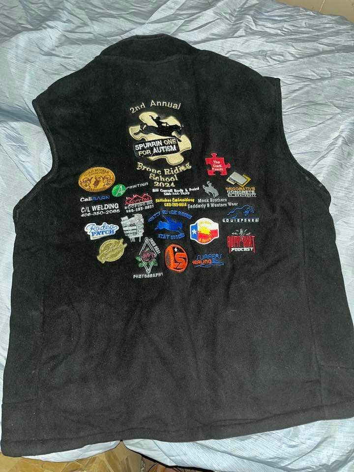 A black vest with a lot of patches on it