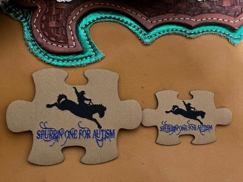 Two puzzle piece-shaped patches with a rodeo rider silhouette and