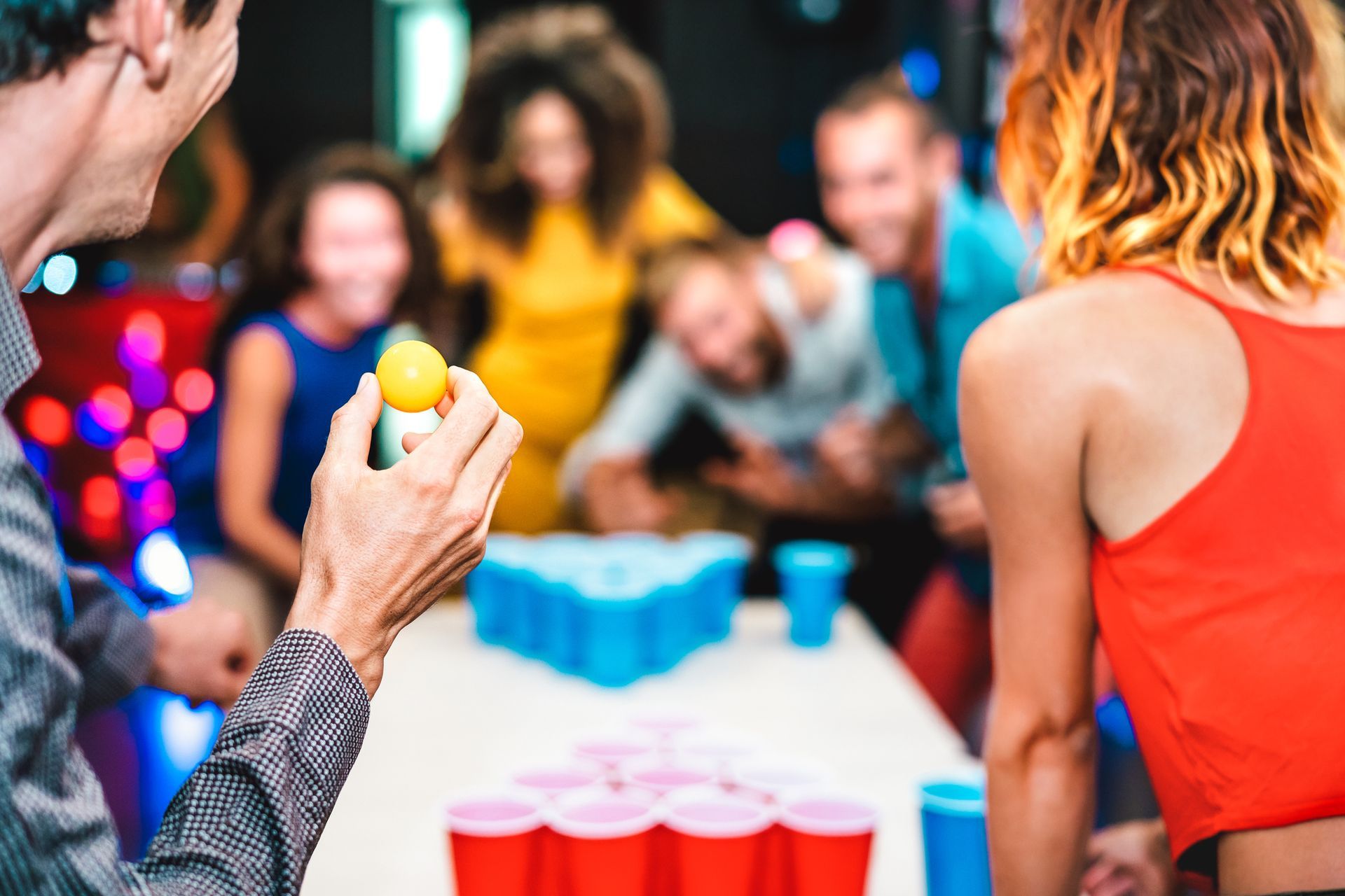 A group of people are playing beer pong at a party.