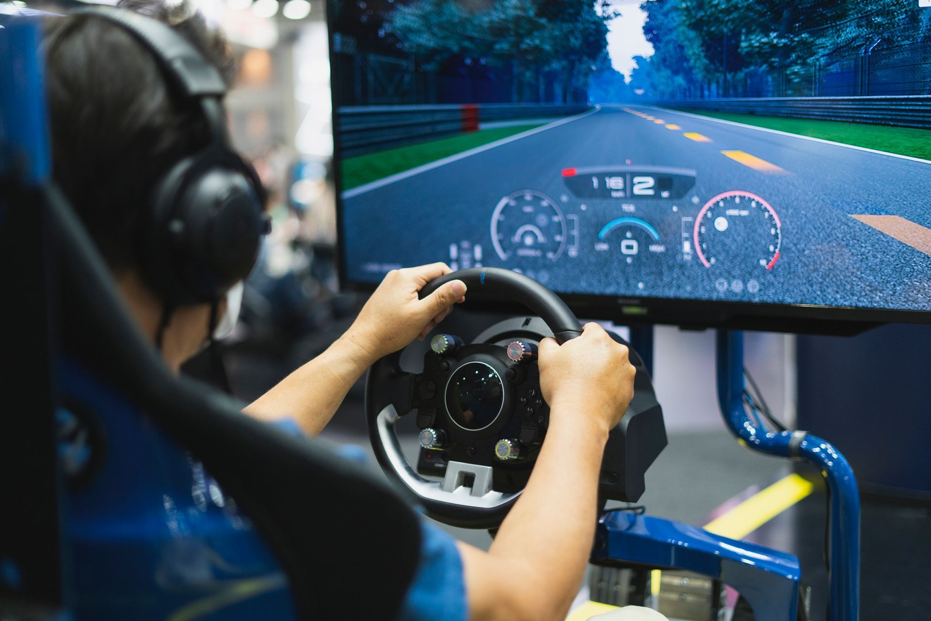 A person is playing a video game on a simulator while wearing headphones.