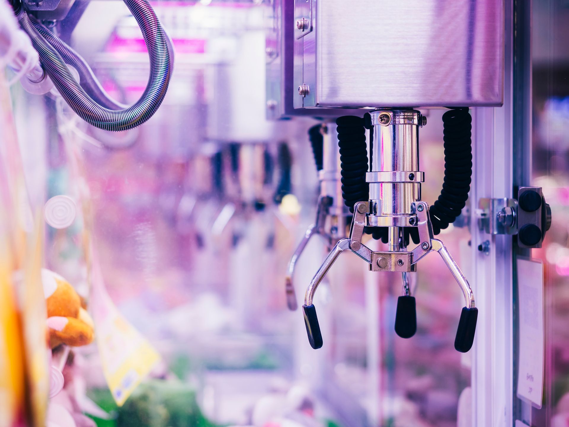 A robotic arm is holding a stuffed animal in a machine.