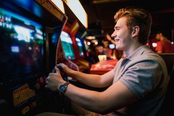 A young man is playing an arcade game in an amusement park.