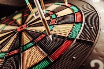 A dart board with a green dart in the center