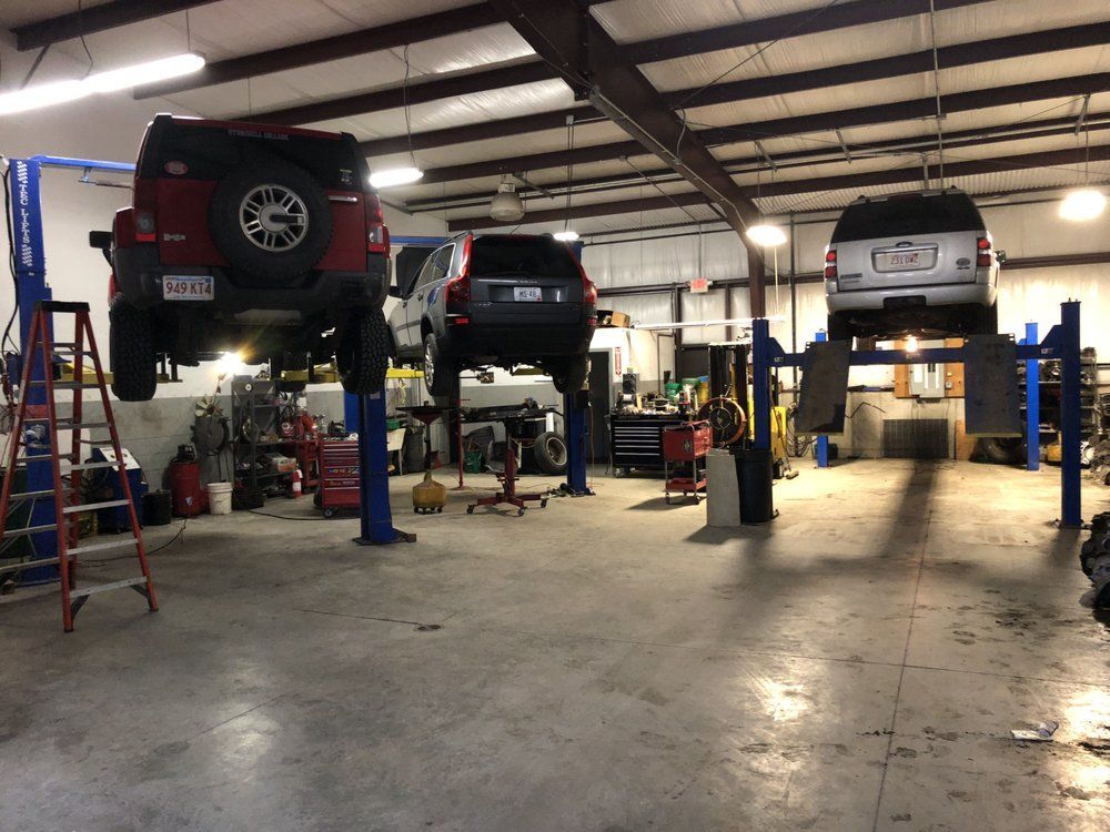 A jeep is sitting on a lift in a garage | Franklin Transmission and Auto Care