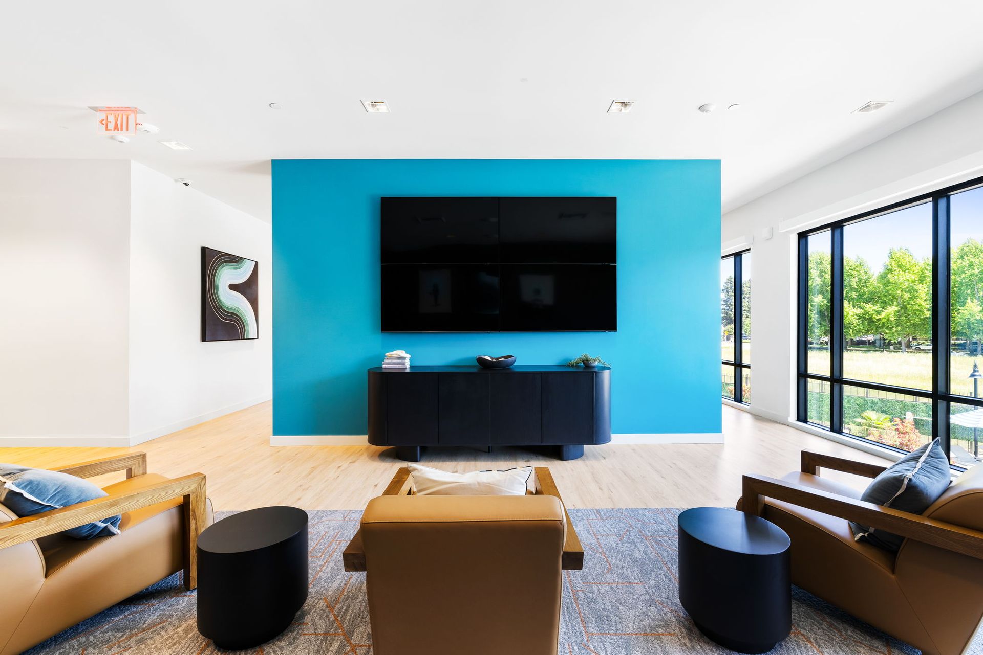 Resident lounge with a blue wall and a flat screen tv on the wall.