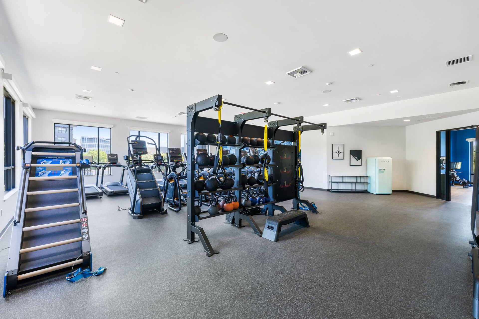 A large gym filled with lots of exercise equipment.