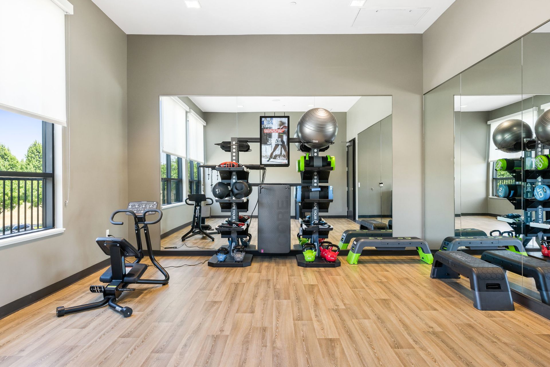 A gym with a lot of exercise equipment and a large mirror.