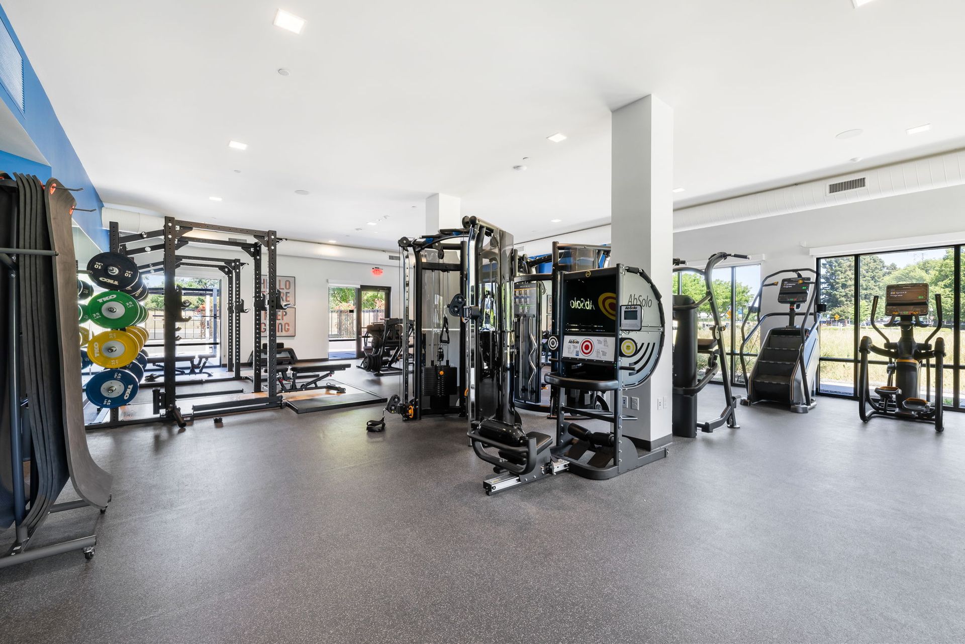 A large gym filled with lots of exercise equipment.