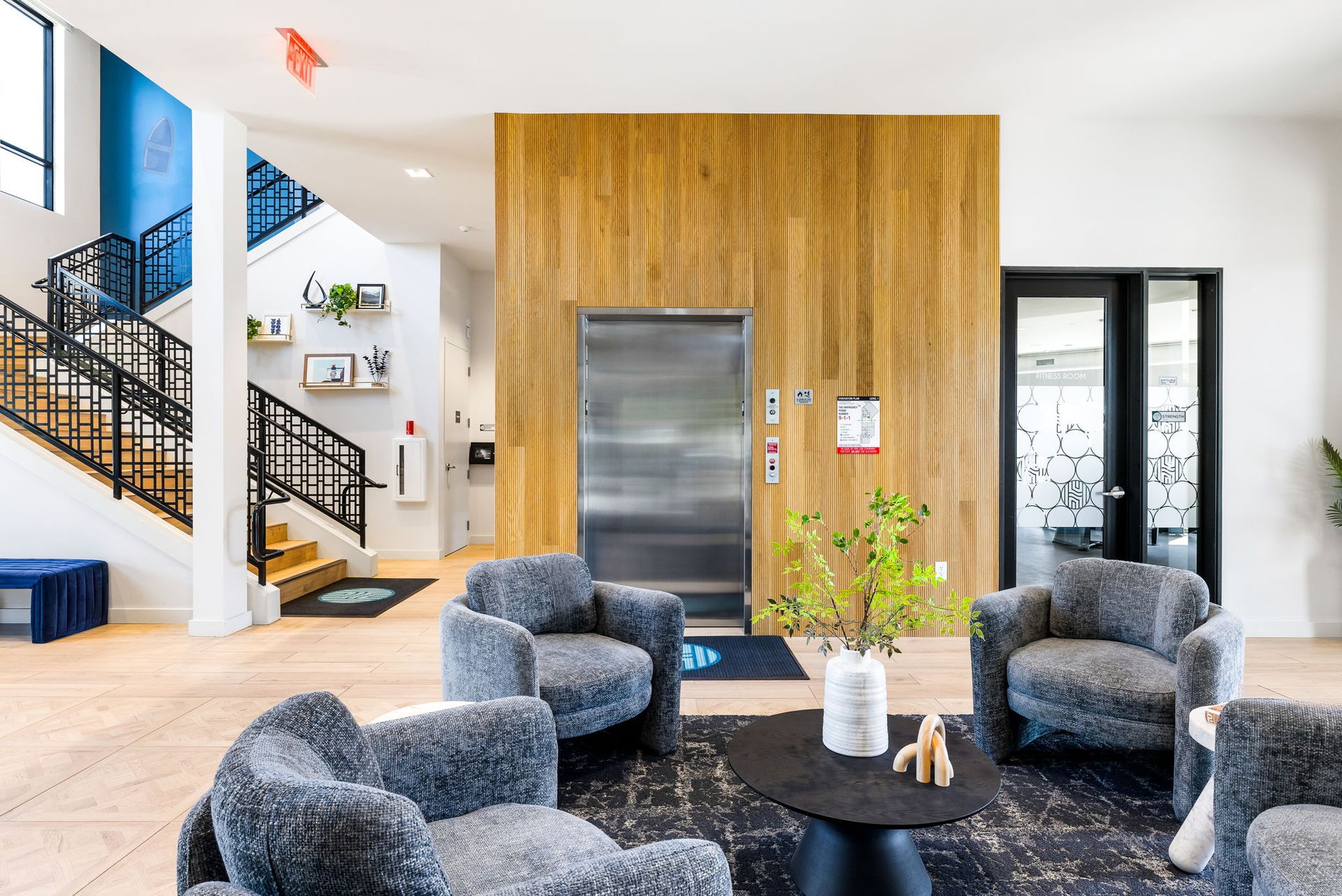 A clubhouse with chairs , a table and an elevator.