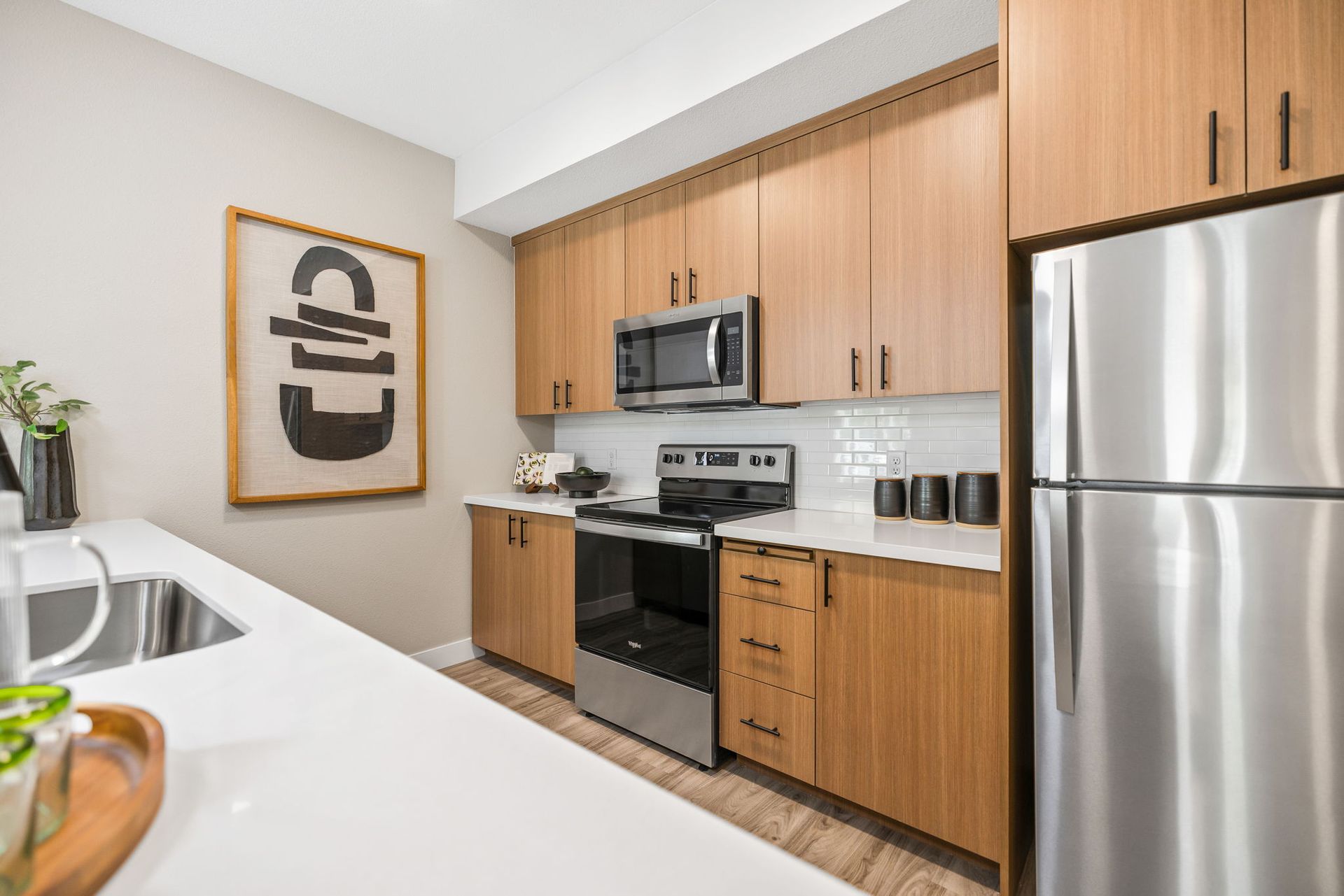 A kitchen with stainless steel appliances and wooden cabinets.
