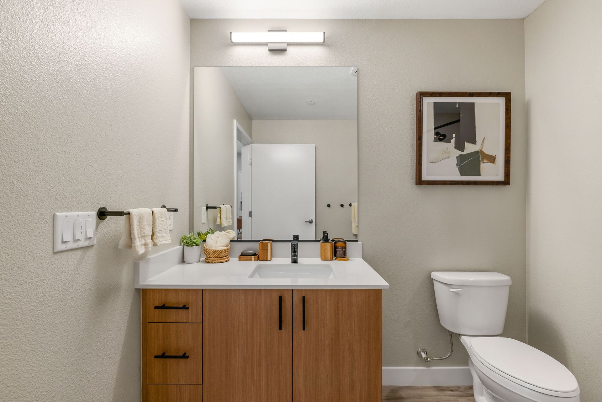 A bathroom with a sink , toilet and mirror.