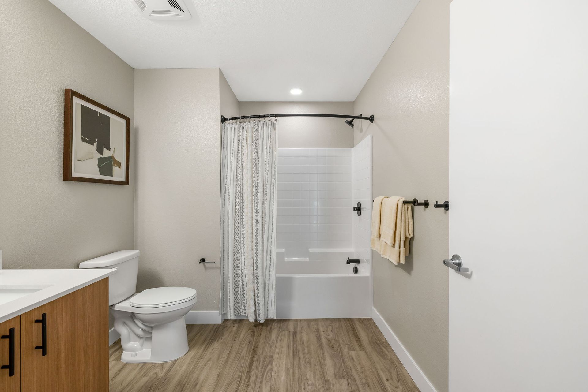 A bathroom with a toilet , sink , shower and bathtub.