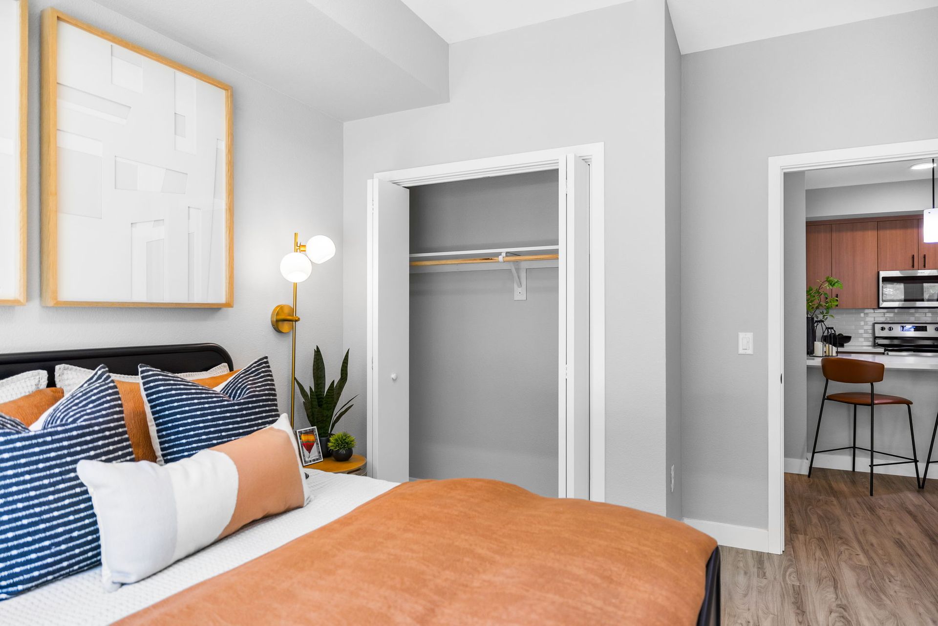 A bedroom with a bed , closet , and mini kitchen.