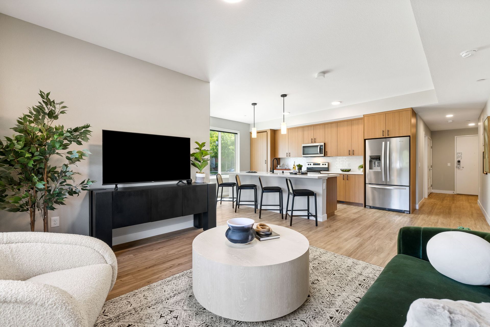 A living room with a round coffee table and a flat screen tv
