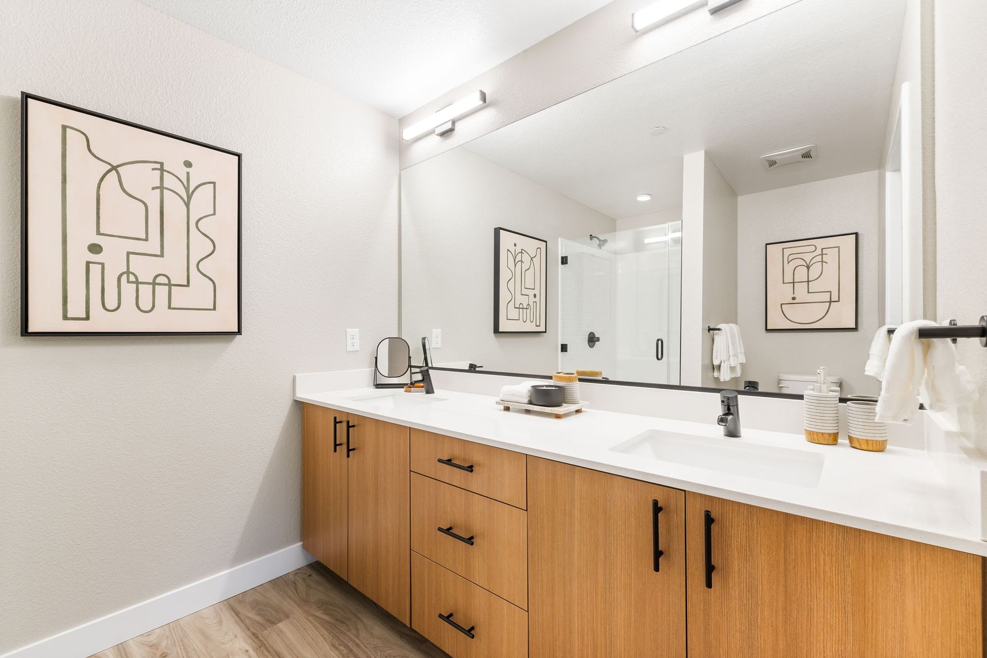 A bathroom with a double sink and a large mirror.