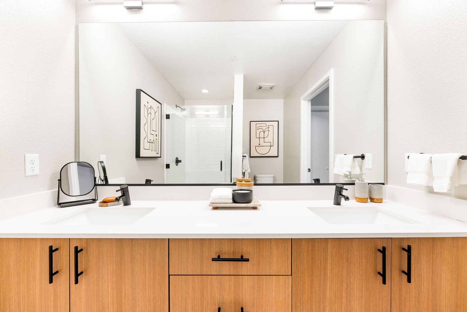 A bathroom with two sinks and a large mirror.
