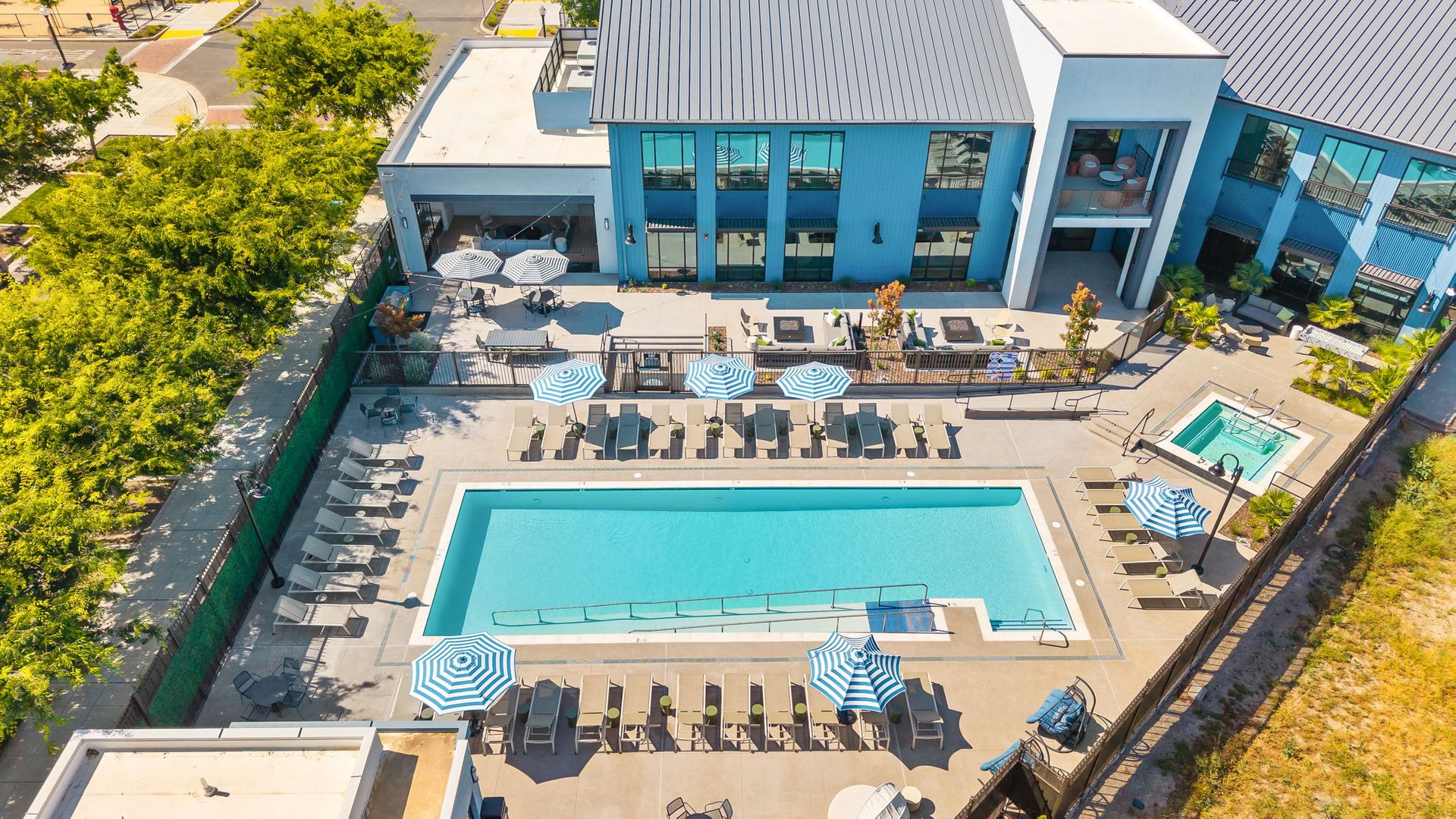 An aerial view of a large swimming pool in front of a building at The Hayley, offers apartments in Sacramento, CA.