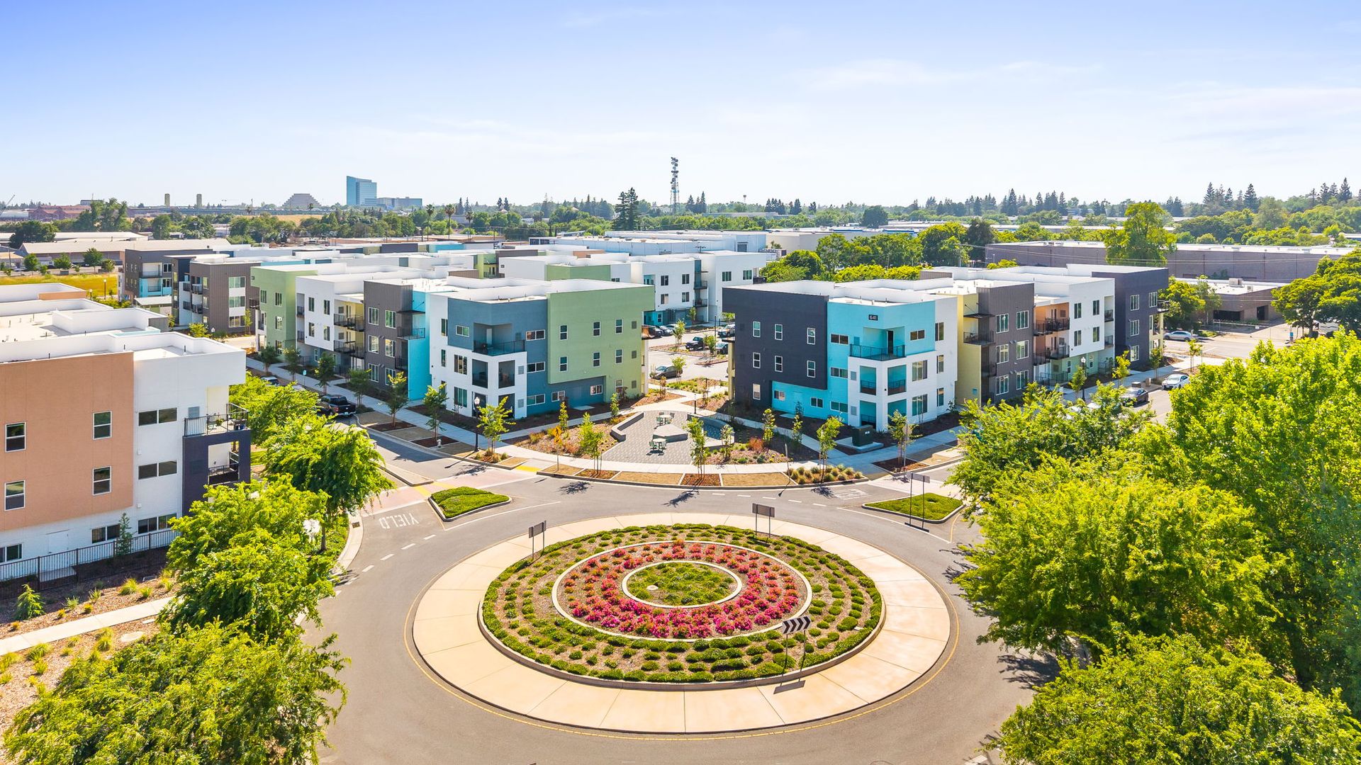 An aerial view of a residential area with a roundabout in the middle.