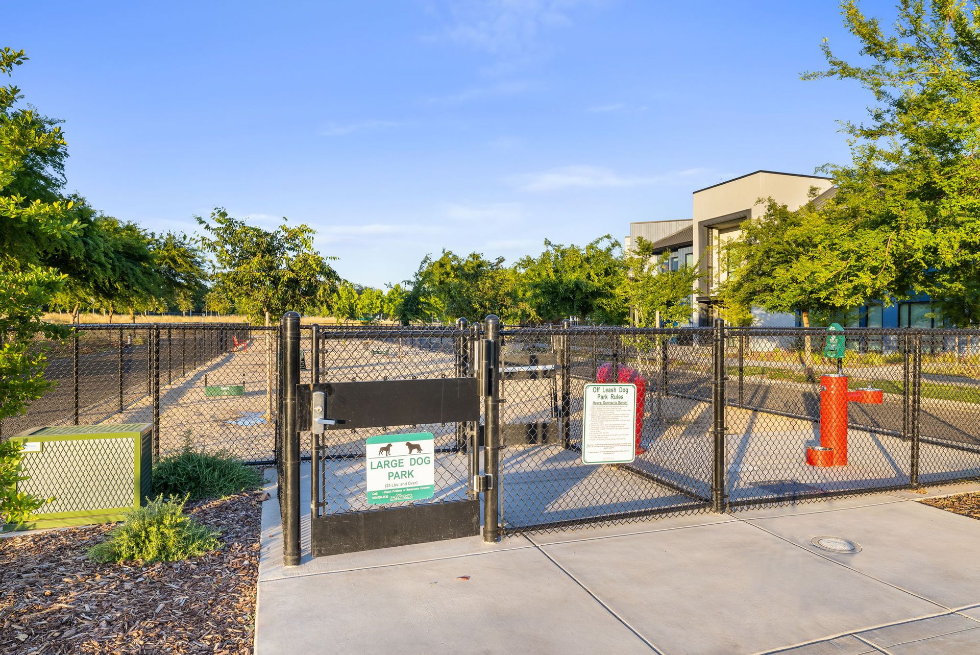 A dog park with a fence and a fire hydrant.
