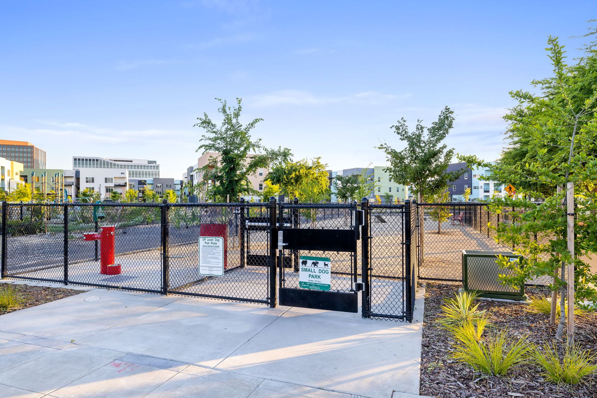 A dog park with a fence and a fire hydrant in the background at The Hayley, offers apartments in Sacramento, CA.