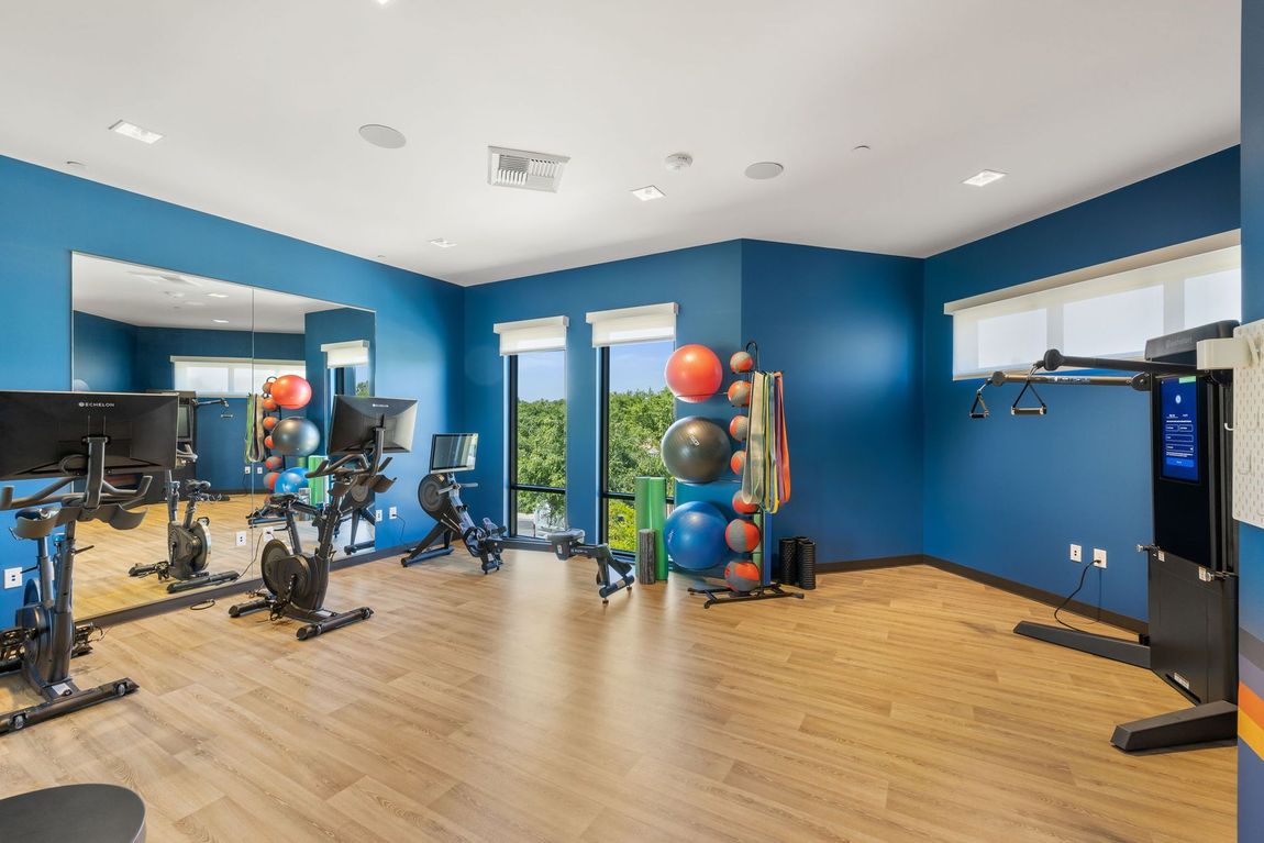A girl is working out in the fitness center, wearing white headphones.