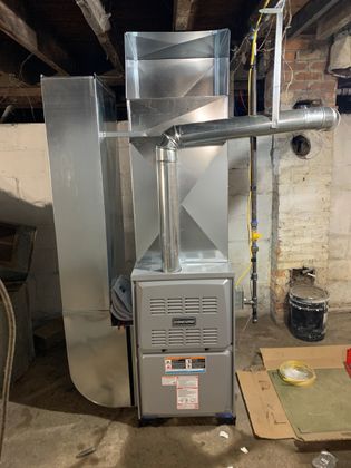 Metal furnace and ductwork installed in a basement utility space. Metal furnace and ductwork installed in a basement utility space.