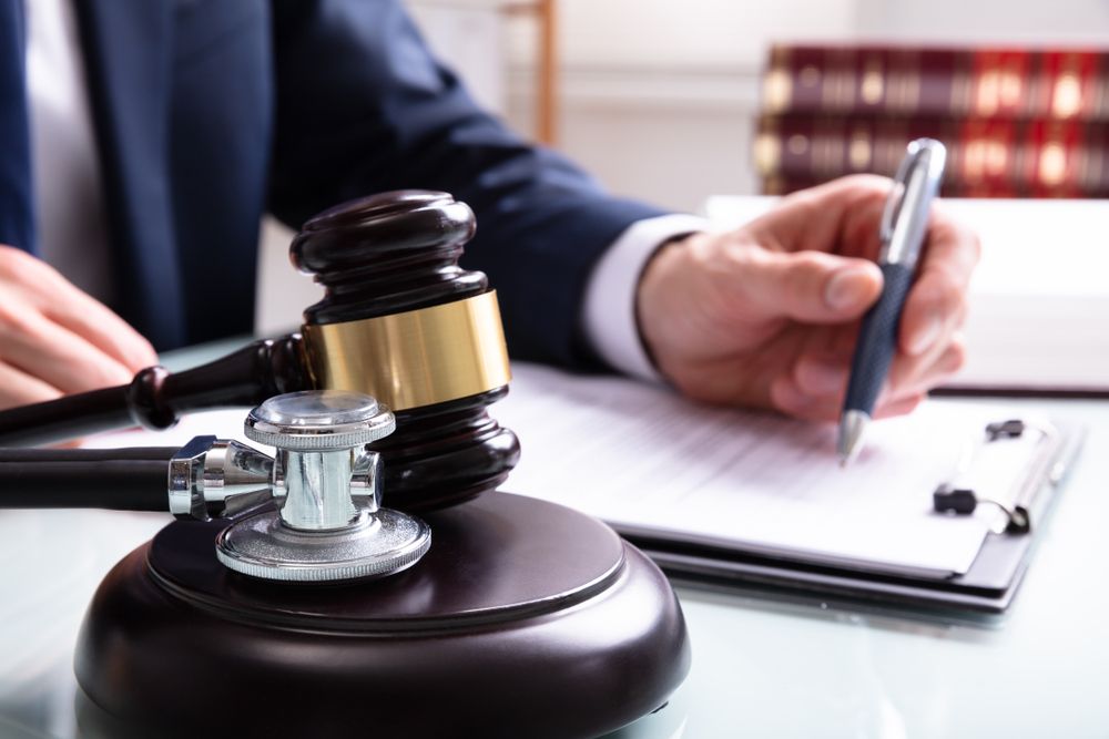 Judge Writing On Legal Documents With Mallet And Stethoscope Over Sound Block In Court - Lawyer in Woy Woy, NSW