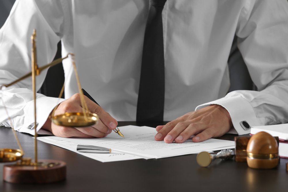 Notary public in office signing document - Lawyer in Woy Woy, NSW