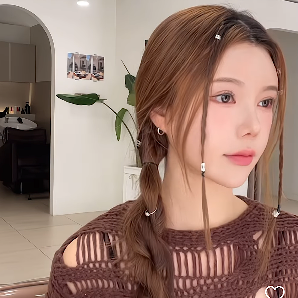 Portrait of a woman in a brown knit top, with long hair and dangling earrings, in a bright room at busan gwangalli haeundae