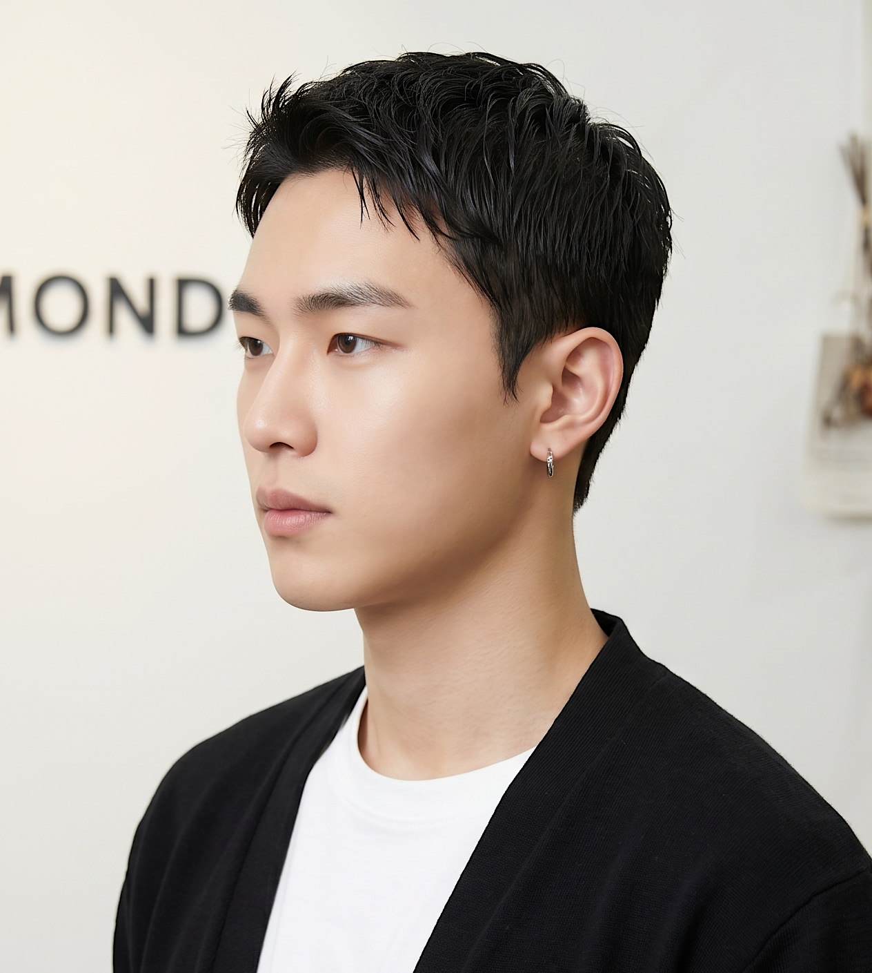 Portrait of a man in a black cardigan and white shirt, shown in profile against a light background at busan gwangalli haeundae