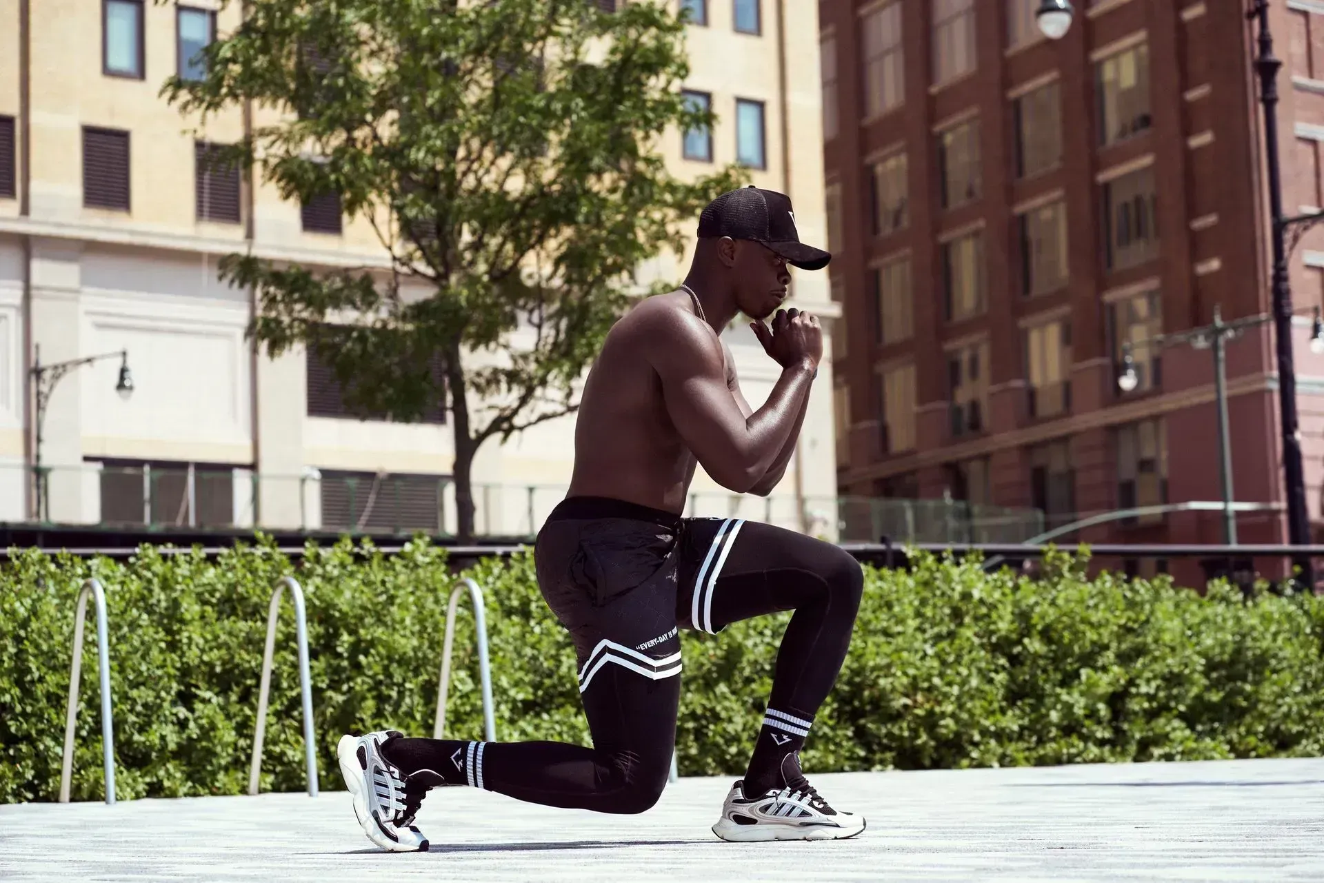 Person in a kitchen scooping food from a cup onto a plate of noodles, rice, and vegetables.