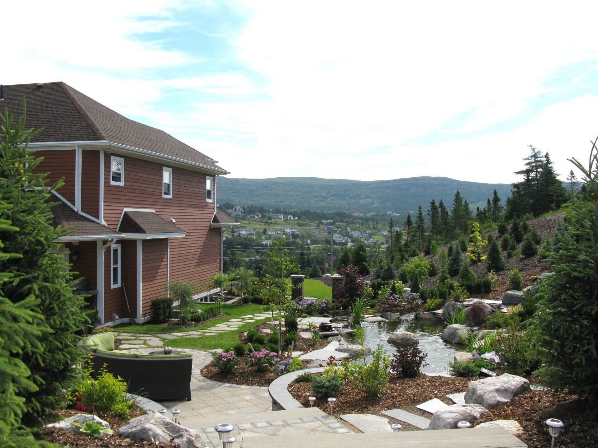 A large brick house sits on top of a hill