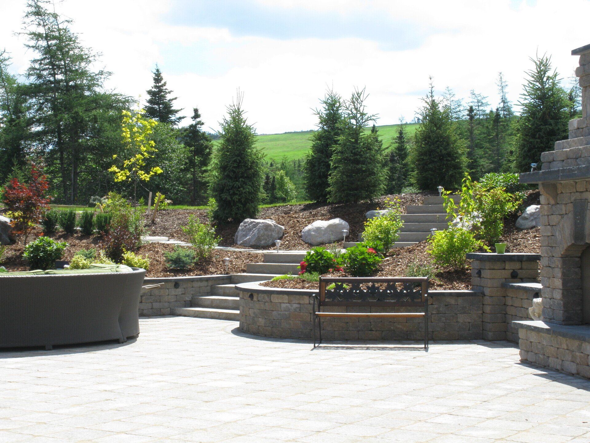 A patio with a bench and a fireplace in the background