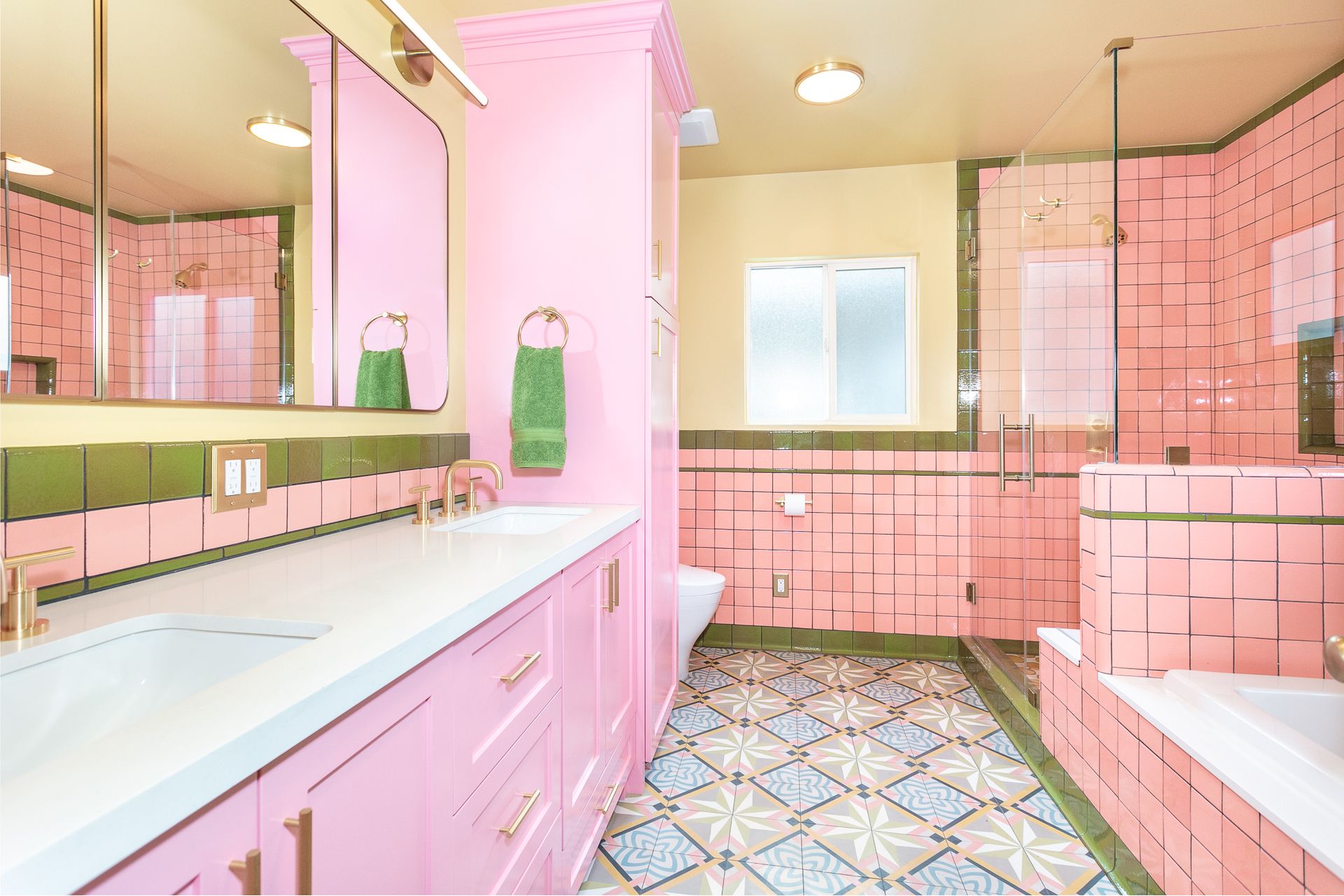 Vibrant bathroom, featuring custom ceramic tile, a bench, a shampoo niche, a built-in tub, a separate shower, and a custom-built vanity and wall cabinet.