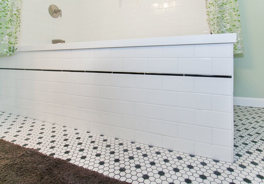 White tiled bathroom with black and white hexagon tile floor.