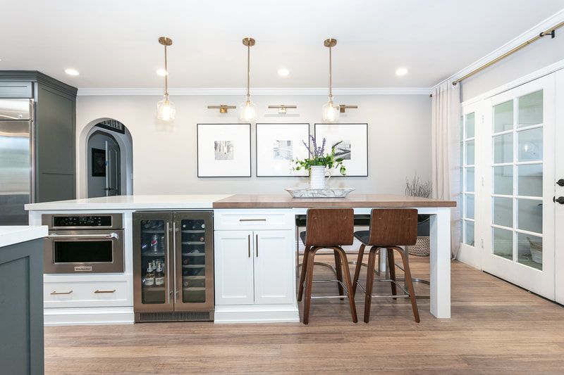 Modern kitchen with an island, bar stools, pendant lights, and French doors.