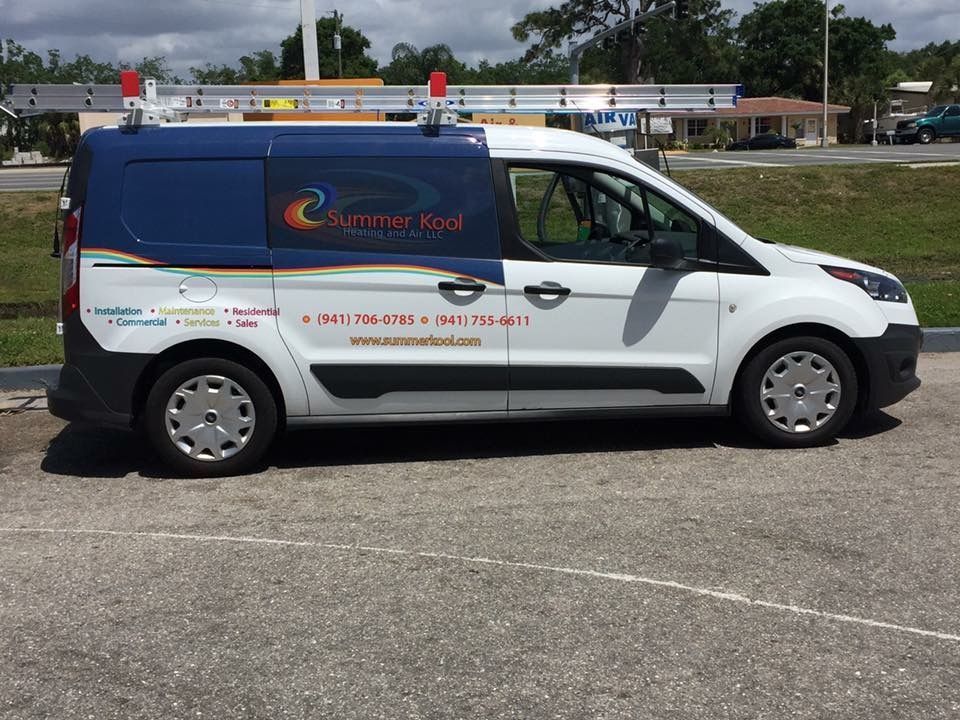 White and blue Summer Kool service van parked on pavement with ladder on top